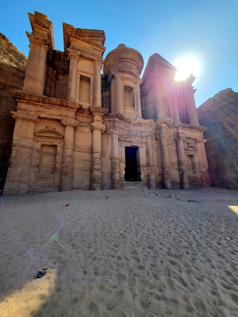 The morning sunlight is split by the carvings of the monastery in Petra.