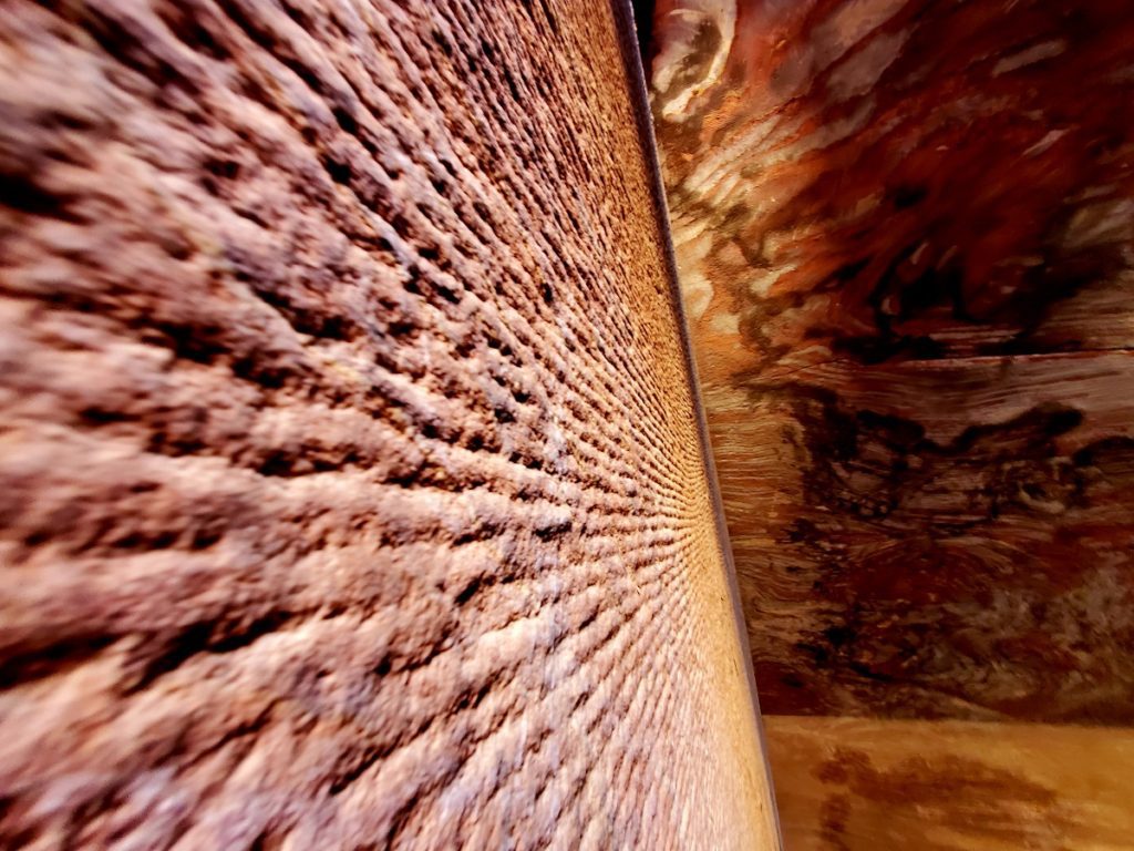 Tool marks line the multicolor sandstone walls of a tomb in Petra.