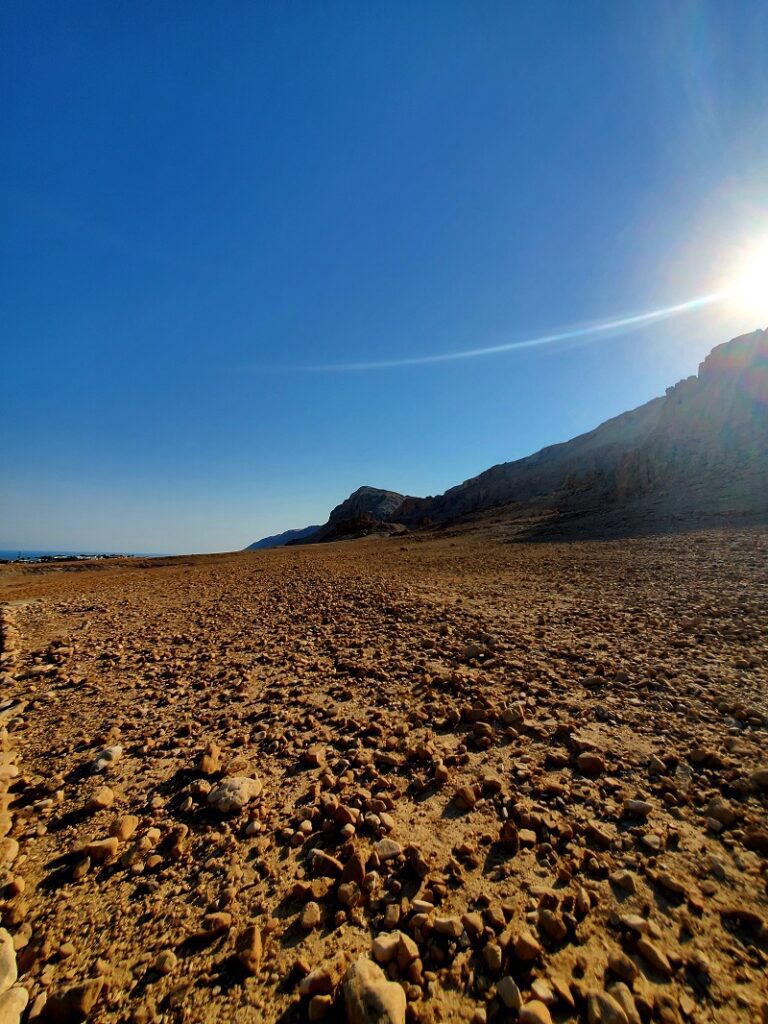 The caves of Qumran in the mountainside of stone along the desert floor. 