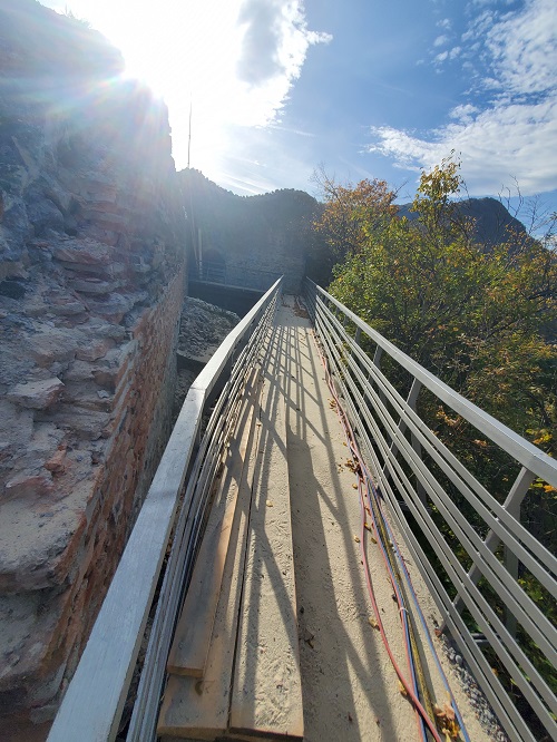 The narrow walkway on top of the ridge, hills slope sharply away on both sides.