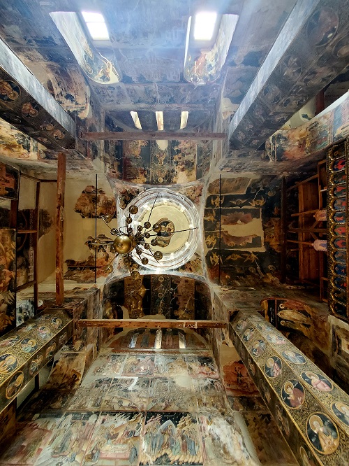 Looking up from the church floor a view of the ceiling and surrounding walls. Painted with a scenes of local Christian motifs and stories.