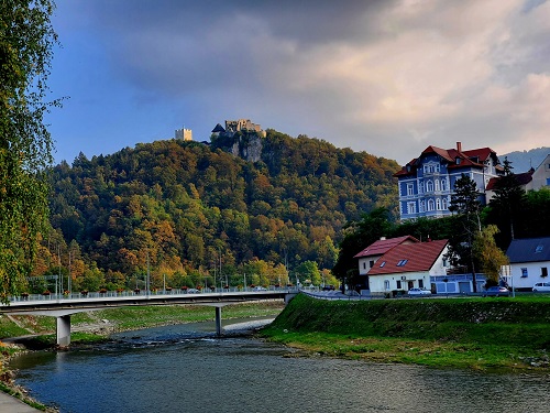 A bridge over the river below and the citadel peeks out of the trees on the ridgetop.